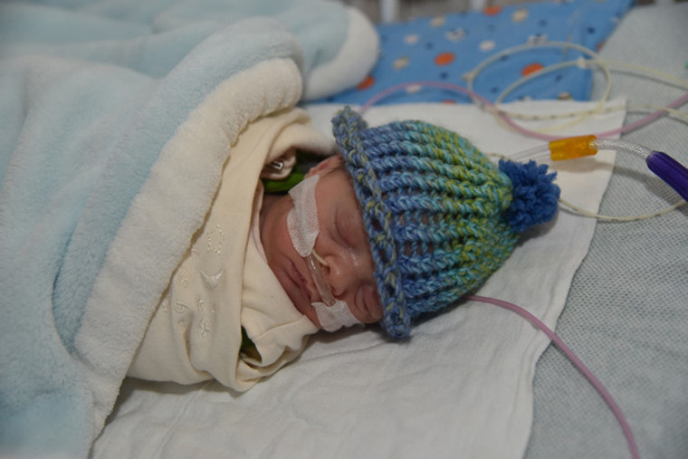 Preterm baby with knit hat.