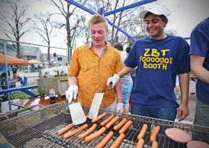 Carson Gaines, left, and Addy Shah prepare food at the Zeta Beta Tau food booth during 2014 Thurtene Carnival. (Photo: James Byard/Washington University)