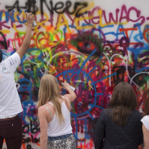 students paint a graffiti mural