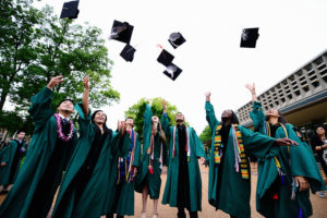 Students toss their mortar boards in the air