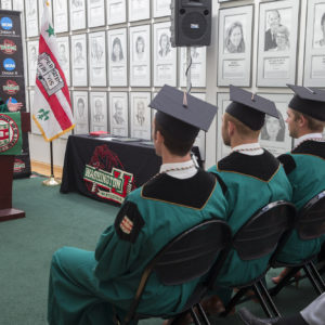 three graduating students listen to Chancellor Wrighton speak