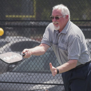 man plays pickleball at Staff Day