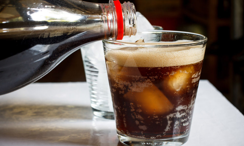 Bottle of soda being poured into a glass