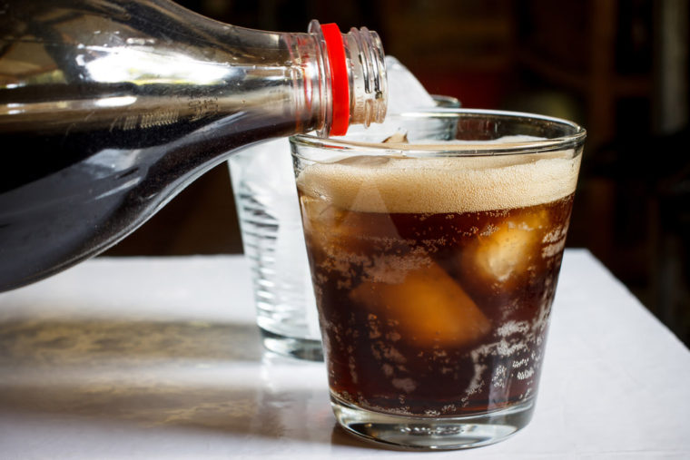 Bottle of soda being poured into a glass