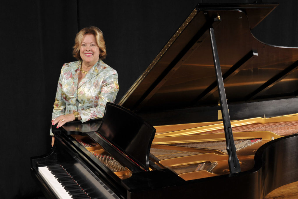 Mary Pillsbury Wainwright, with the Steinway Grand Piano she donated to the music department. The Pillsbury Theatre will be formally dedicated Sept. 10. (Photo: Kevin Lowder/Washington University)