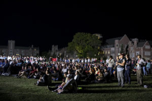 students on lawn watch the debate