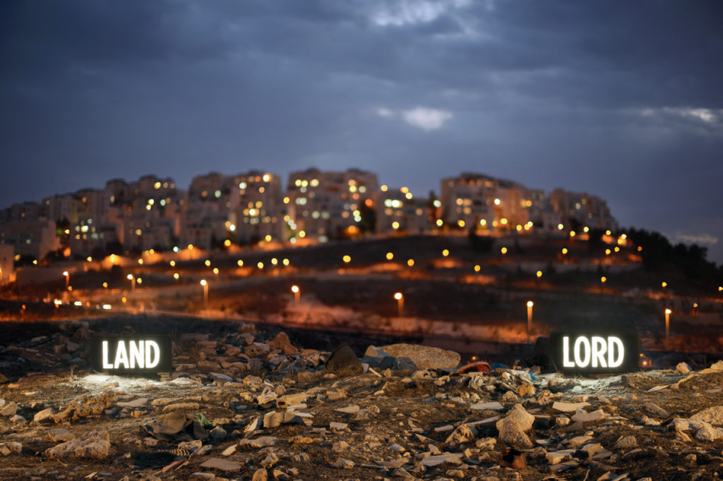 Shimon Attie, "LAND LORD." two on-location light boxes, looking onto the Israeli settlement Har Homa from the Palestinian Village Umm Tuba, annexed by Israel in 1967, 2014. Digital c-print. 49 1/8 × 73 1/8 × 2 1/8 inches. ©Shimon Attie. Courtesy the artist and Jack Shainman Gallery.