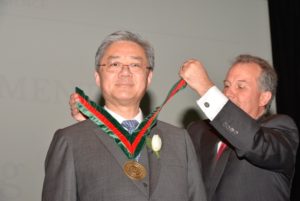 Peter Young receiving his distinguished alumni award (a medal) from Dean Aaron Bobick.