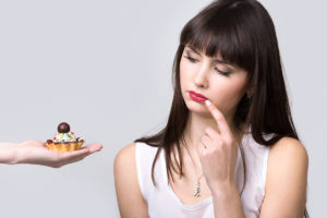 woman considers tasty dessert