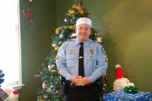 Don Moore in front of a tree and gifts