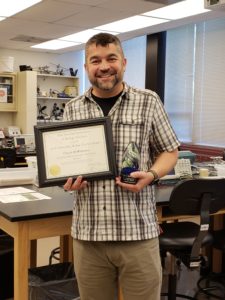 Teacher holding award