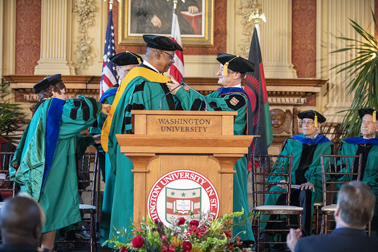 Peter Mutharika, president of the Republic of Malawi, was conferred with an honorary doctor of humane letters during a special ceremony Sept. 30 in Holmes Lounge. Assisting with his hooding are (from left) trustees Maxine Clark and John F. McDonnell and Chancellor Mark S. Wrighton.