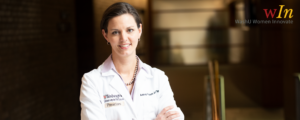Physician and researcher Dr. Audrey stands with her arms crossed wearing a white lab coat emblazoned with the logo of the Washington University School of Medicine in St. Louis