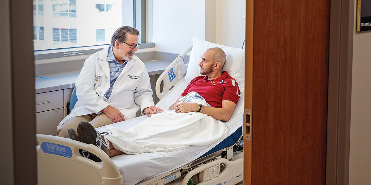 John F. DiPersio speaks with a patient