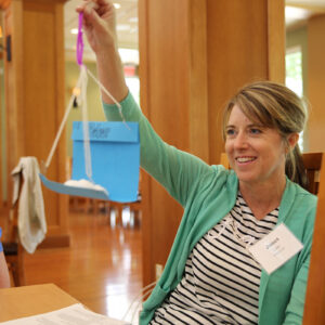 Teacher proudly holds up a paper creation made at the conference.