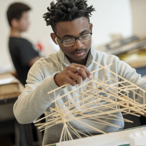 student holds art project