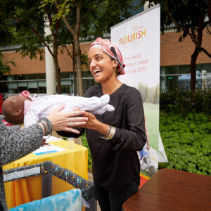 Maleeha Ahmad hands an infant doll to an individual.