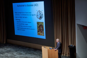 Marco Colonna adresses a group about alzheimers on stage.