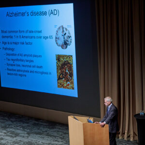 Marco Colonna adresses a group about alzheimers on stage.