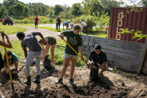 students shovel dirt in garden