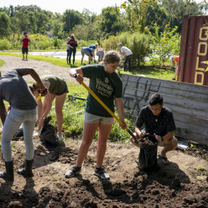 students shovel dirt in garden