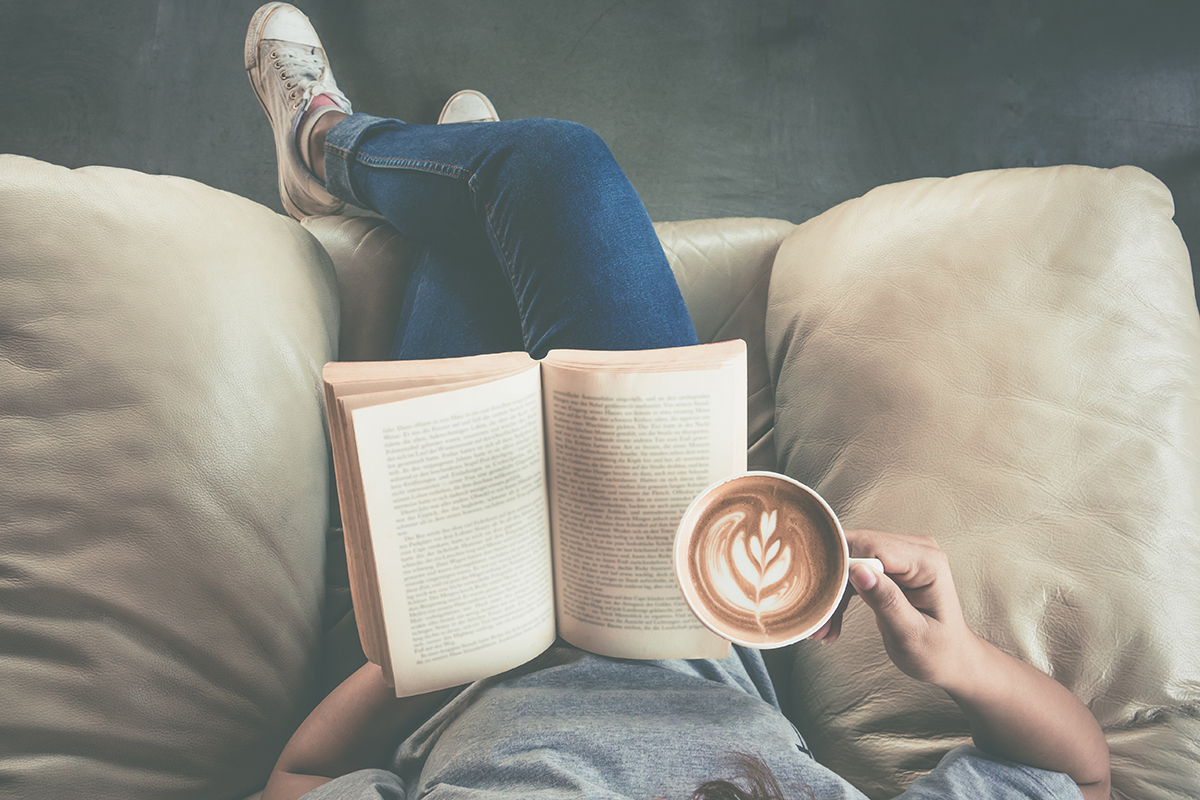 Girl in armchair reading with coffee