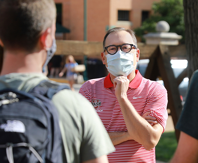 At a safe distance, Chancellor Andrew D. Martin welcomes new and returning students and their parents during move-in. (Photo: James Byard/Washington University)