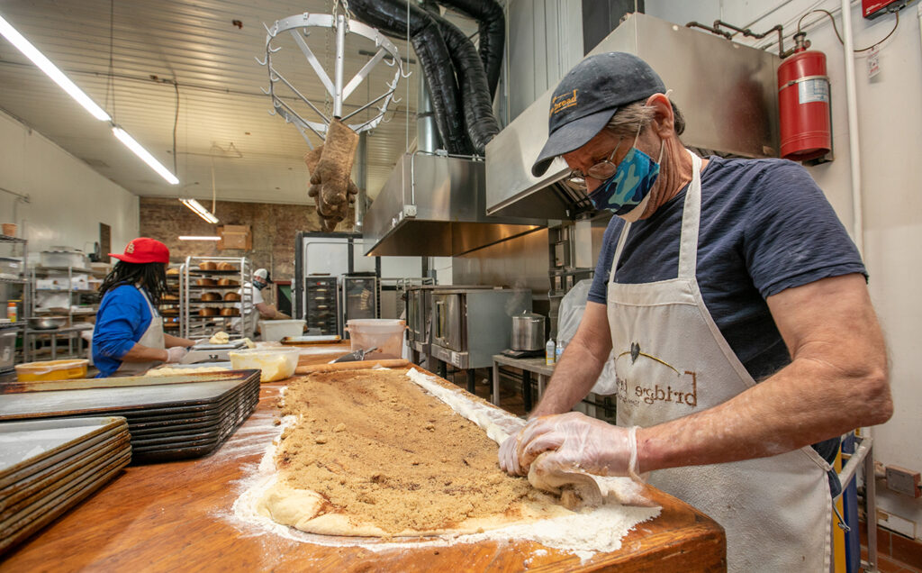 From right: Kevin Turnbull (blue hat & shirt) prepares cinnamon