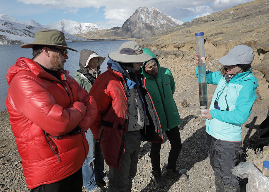 Bronwen Konecky (right) examines a sediment core sample with the research team. (Photo: Tom Malkowicz)