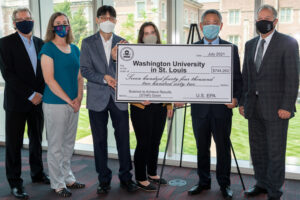 Professors Moon and Parker with Dean Bobick and Edward Chu. Parker and Moon hold a comically large check