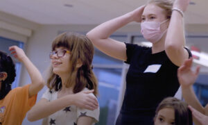 student volunteer helping child with cerebral palsy