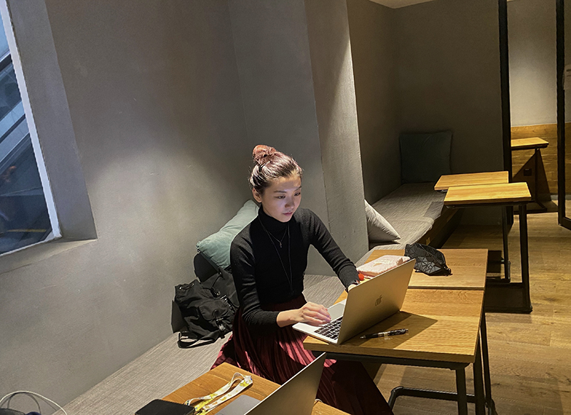 Arts & Sciences sophomore Serena Wu working on her laptop in an empty room