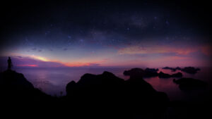 Man climbing rocks with a panorama view and purple sky sunset on an archipelago island