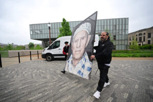 Luigi Toscano tests a portrait installation in front of the Summers Welcome Center for his exhibition "Lest We Forget."