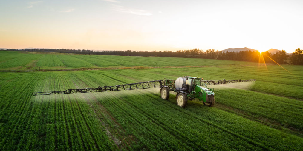 A farmer sprays pesticides on crops.