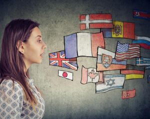 Photo of woman speaking toward a graphic of various world flags.