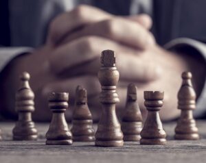 Folded hands behind a chess set