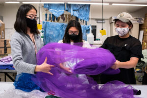 students unroll fabric at a meeting
