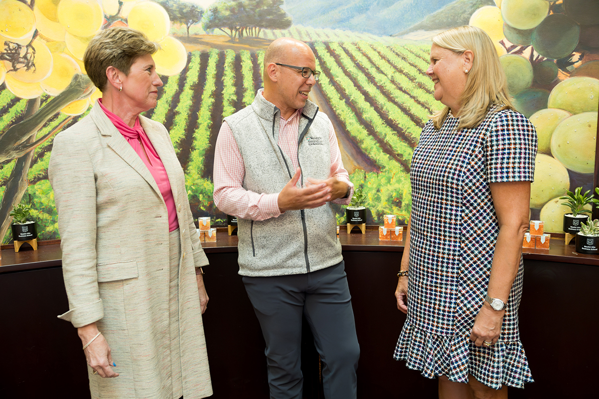 Olin Business School alum Merry Mosbacher (left) and Nina Leigh Krueger (right) engage with Michael Mazzeo, dean of Olin Business School, at the Power of Women in Business event