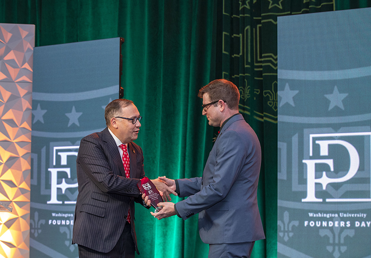 Chancellor Andrew D. Martin presents John Hendrix with the Distinguished Faculty Award at the university’s Founders Day ceremony.