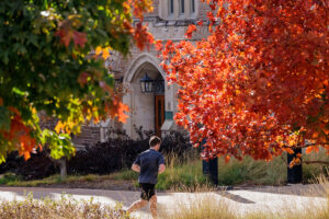 A runner passes fall foliage