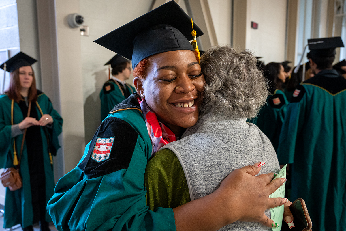 Graduate Timeca Davis hugs academic advisor Elisa Wang