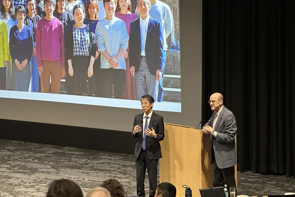 Noboru Mizushima, MD, PhD, speaks at a symposium as Dean David Perlmutter looks on