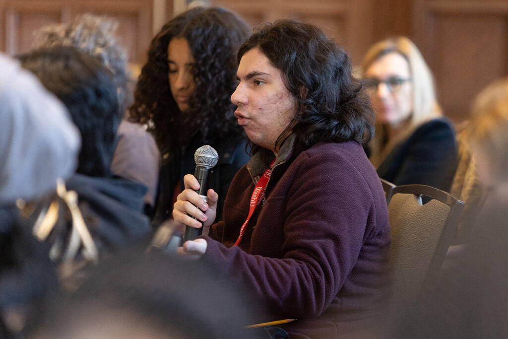 A student holds a microphone to answer a question