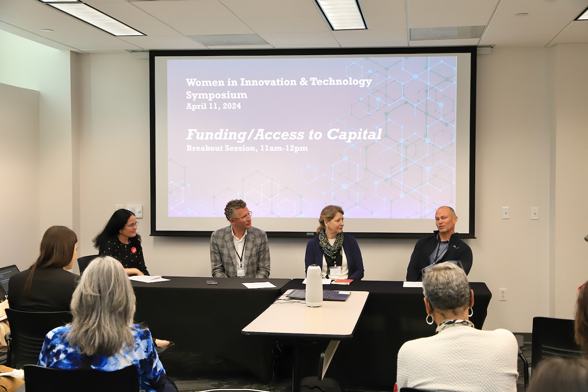 Panelists speak before an audience