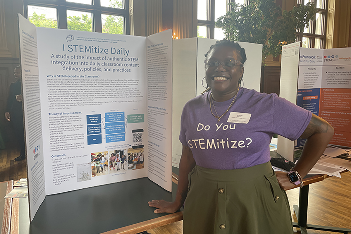 Brandie Starks poses in front of poster