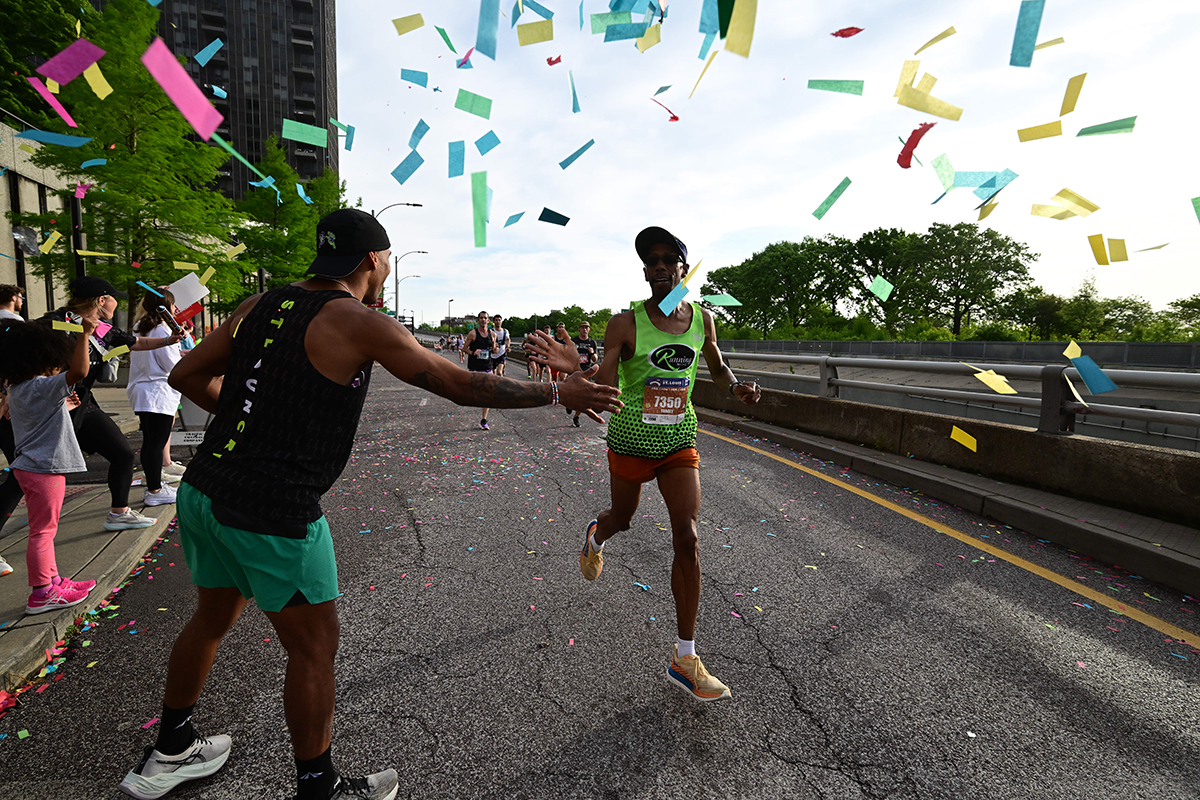 A runner gives a spectator a high-five 