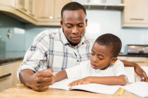a man helps a child with homework