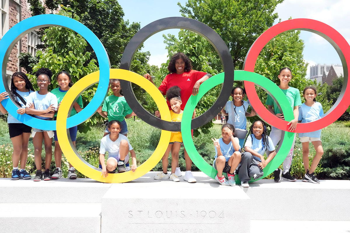 Olympic medalist Jackie Joyner-Kersee and kids pose at the Olympic rings