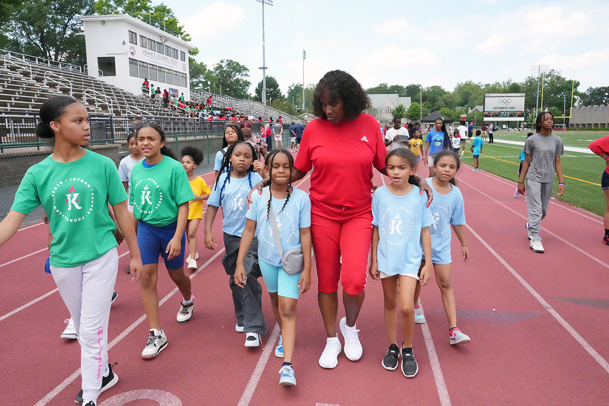 Olympic medalist Jackie Joyner-Kersee and kids on Francis Olympic Field